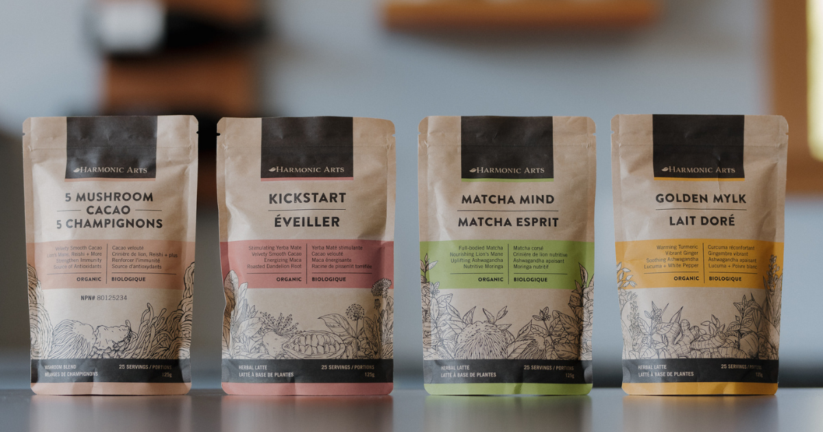 Image features a lineup of Harmonic Arts Herbal Lattes. From left to right, there is a bag of 5 Mushroom Cacao, Kickstart, Matcha Mind, and Golden Mylk.